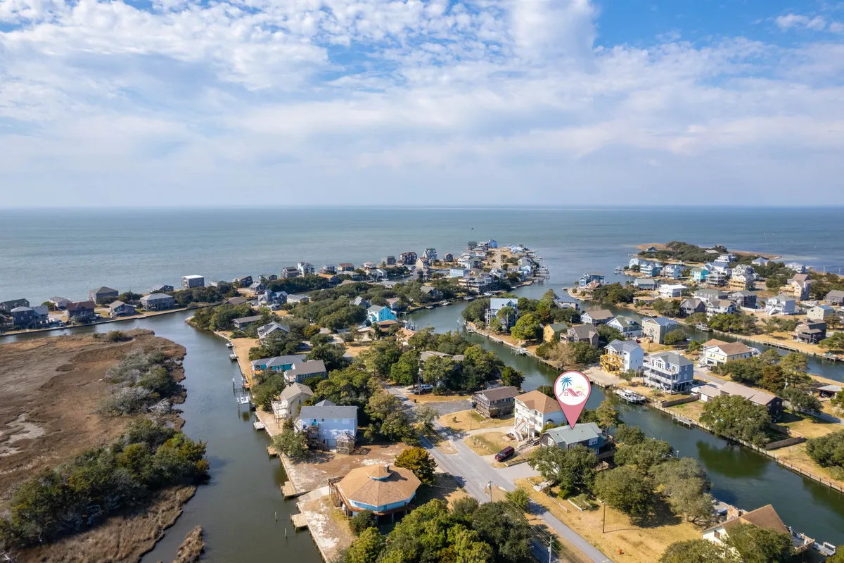 A wide view of picturesque canals lined with houses and bordered by trees. The waterway is serene, and the scene encourages exploration by foot or kayak, with community parks nearby. The mood is peaceful and invites outdoor discovery in a residential, nature-infused setting.