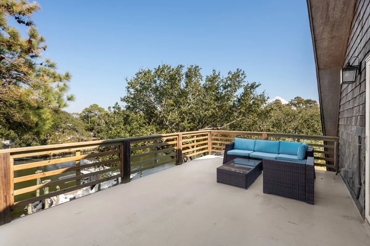 An outdoor seating area nestled among trees with views of the water, offering a peaceful spot for relaxing, entertaining guests, enjoying coffee, or stargazing at night.